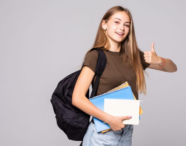 Young student woman with backpack bag holding hand with thumb up gesture over white background